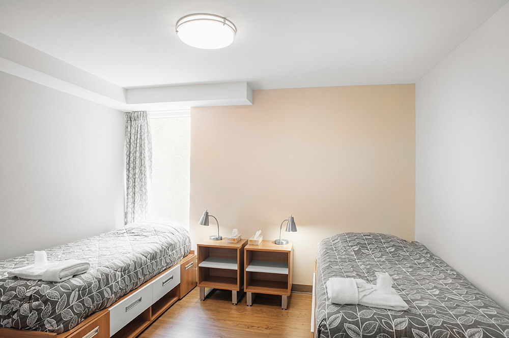 Chambre avec deux lits simples dans un appartement à deux chambres